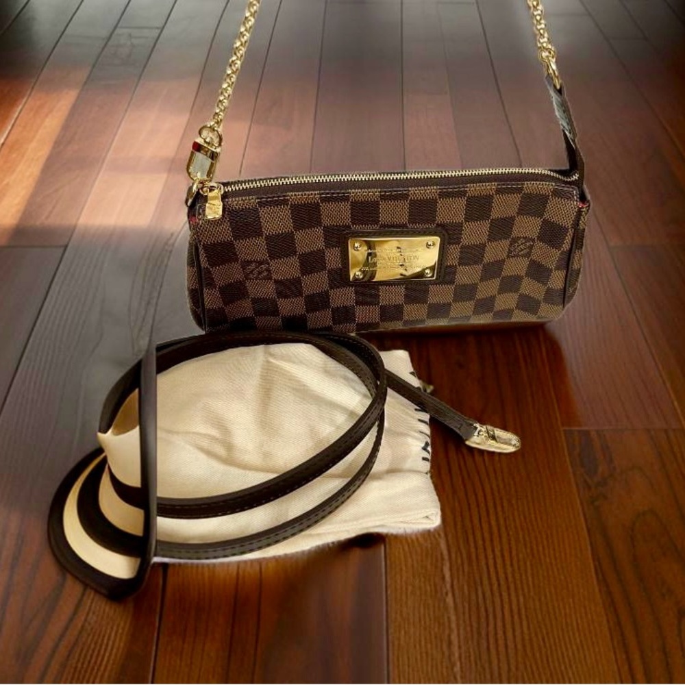Authenticated Louis Vuitton Eva Clutch Damier Ebene Bag with shoulder strap.